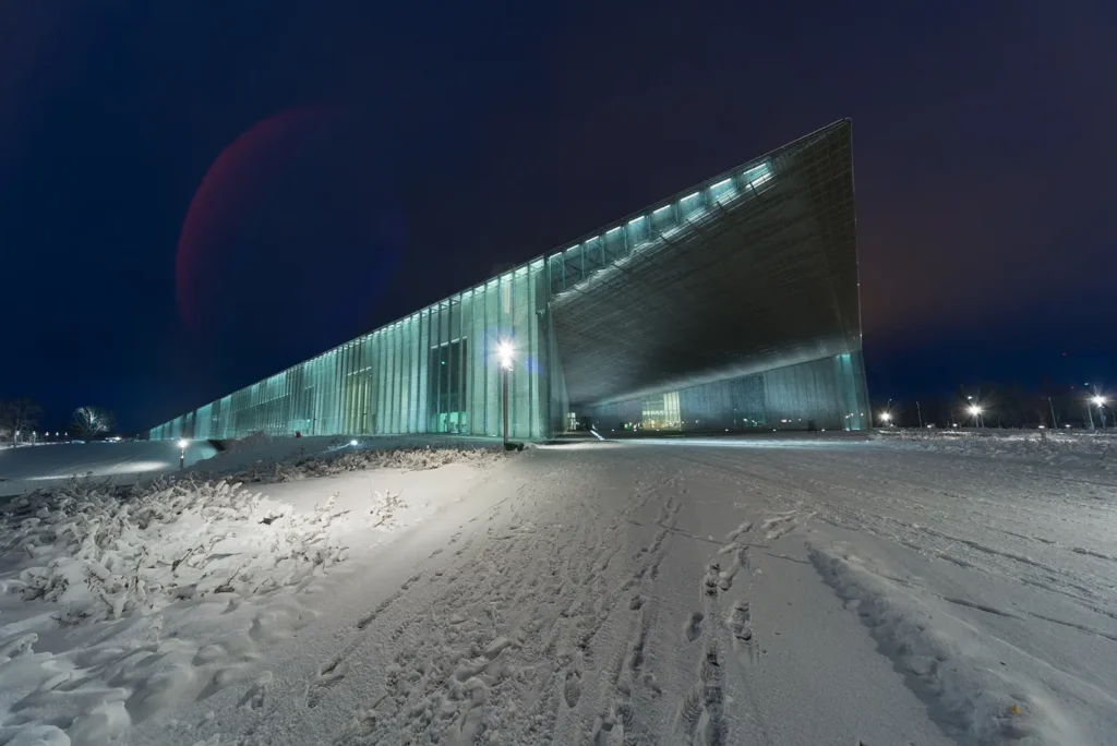 The illuminated Estonian National Museum building on a snowy winter evening.