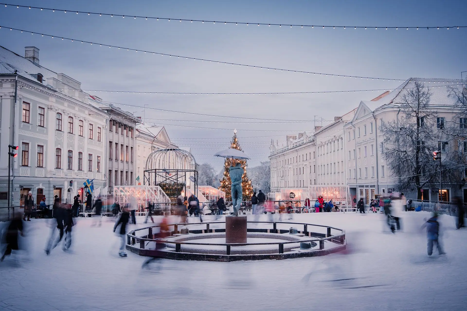 Uisutajad talvisel Tartu Raekoja platsil Suudlevate Tudengite purskkaevu ümber.